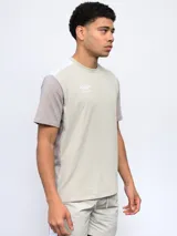 Remera deportiva Umbro de corte clásico, color gris con mangas cortas blancas y logo de la marca en el pecho.