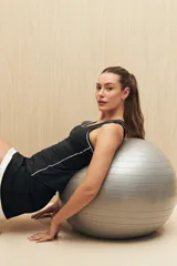 Musculosa deportiva negra con cuello redondo y ribetes blancos en cuello, sisas y laterales.