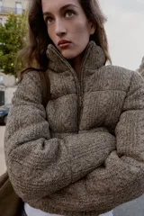 Anorak estilo bomber con diseño acolchado y tejido de punto con textura. Presenta cuello subido, cierre frontal con cremallera, mangas largas con elástico interior y bolsillos delanteros de vivo con forro polar. El bajo cuenta con acabado elástico.