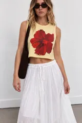 Top de corte crop y tirantes anchos, color amarillo con gran estampado de flor de hibisco roja en el centro.