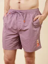 Short de baño de color liso con cintura elástica ajustable mediante cordón y detalle de parche con logo en la parte inferior.