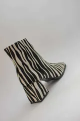 Botas plateadas de cuero con caña media, cierre lateral con cremallera, punta cuadrada y tacón geométrico de madera.