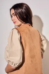 Chaleco sin mangas de color marrón, con diseño acolchado y bordados florales en toda la superficie. Presenta un corte recto y terminaciones con ribetes al tono.