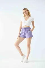 Short de tiro alto con cintura elástica y cordón ajustable. Presenta un corte recto y bolsillos laterales.