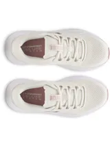 Championes de running Under Armour modelo Charged Surge 4, color blanco con detalles en rosa suave. Presentan una parte superior de malla transpirable con superposiciones sintéticas, entresuela Charged Cushioning para mayor amortiguación y suela de goma resistente.