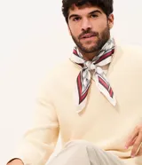 Pañuelo cuadrado de poliéster color blanco con estampa geométrica de círculos y bordes con franjas en rojo, negro y gris, de la marca Renner.