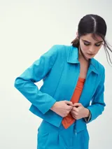 Chaqueta celeste con cierre frontal, cuello clásico y mangas largas.