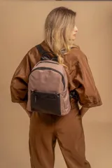 Mochila urbana de diseño combinado, confeccionada en tela resistente con bolsillo frontal y detalles en cuero sintético. Cuenta con compartimento principal con cierre y correas ajustables.