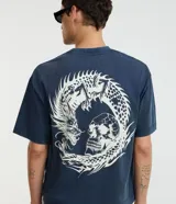 Remera boxy fit azul marino con cuello redondo y manga corta, confeccionada en algodón. Presenta un gran estampado en la espalda que combina un dragón y una calavera.