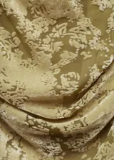 Top entallado de terciopelo con diseño drapeado y escote asimétrico. Presenta una textura aterciopelada con efecto desgastado en tonos verde oliva.