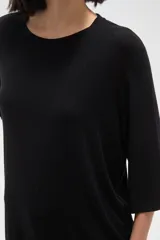 Remera de viscosa en color verde oliva, con cuello redondo y mangas 3/4. Presenta un diseño de tejido acanalado y corte holgado.