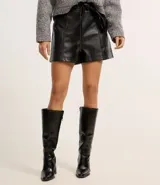 Short corto color marrón oscuro, confeccionado en poliuretano (PU) con textura que imita el cuero. Presenta cintura elástica en la parte trasera, lazo delantero para ajustar y recortes decorativos.