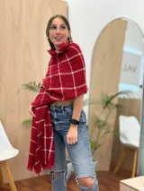 Bufanda rectangular color rojo con estampado de cuadros blancos y terminación con flecos.