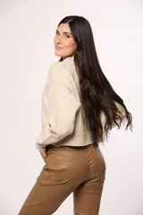 Buzo tejido de punto color beige, con cuello redondo, mangas largas con puños ajustados y diseño de corte cropped.