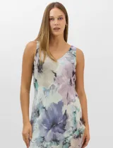 Conjunto compuesto por un vestido midi de gasa con estampado floral en tonos violeta, azul y crema, con escote en V, tirantes anchos y ruedo asimétrico con volados. Incluye una chaqueta corta tipo torera de mangas 3/4 confeccionada en la misma tela. Posee forro interno a tono.