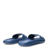 Sandalia tipo slide marca Umbro, color azul, con banda superior ancha que presenta el logo de la marca en relieve color blanco.