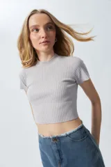 Top gris de tejido de punto acanalado, elastizado, de manga corta y cuello alto.