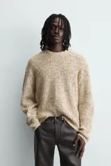Jersey de punto con textura acanalada y diseño jaspeado en tonos beige y amarillo. Presenta un corte relajado, cuello redondo y mangas largas con acabados en rib.