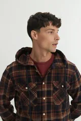 Sobrecamisa de franela gruesa a cuadros color marrón, azul y beige, con capucha forrada, bolsillos en el pecho con tapa, botones personalizados y calce holgado.