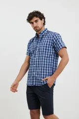 Camisa de manga corta con estampado a cuadros en tonos azul oscuro y celeste. Tiene cuello abotonado y corte clásico.