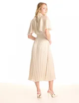 Vestido midi color beige de satén, marca Julia Jordan. Cuello alto con punto smock, mangas amplias de estilo fluido y cintura elastizada también con punto smock. La falda tiene una caída fluida con plisado. Cierre posterior con abertura ojal y botones. Forro interno a tono.