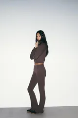 Pantalón de felpa marrón, de tiro alto con cintura elástica y diseño flare acampanado en las pantorrillas.