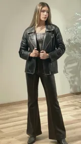 Chaqueta de cuero negra con detalles de tachas en los hombros y espalda.