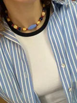 Collar doble de abalorios multicolor con cuentas de acrílico en tonos beige, azul, rojo y celeste, intercaladas con piedras y cristales. Cuenta con cadena y cierre de acero.