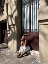 Sandalias de cuero marrón con tiras entretejidas y suela de goma negra.