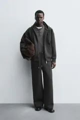 Pantalón de corte wide fit confeccionado en tejido técnico con efecto neopreno. Presenta cintura elástica ajustable con cordón, perneras anchas con costura frontal, bolsillos laterales y bolsillos traseros de plastrón.