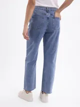 Jean de corte recto con tiro medio, confeccionado en denim azul clásico con acabado de ruedo desflecado.