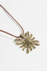 Collar de cordón marrón con dije metálico en forma de sol con la inscripción 'YO RU GUA' en el centro.