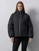 Campera beige capitoneada con capucha, cierre frontal y bolsillos laterales.