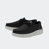 Zapatos Hey Dude modelo Wendy Rise, de lona color negro con detalles brillantes, suela de plataforma blanca y cordones elásticos.