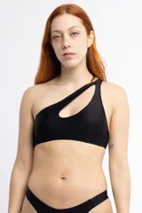 Top de bikini negro de un solo hombro con un corte asimétrico en el escote.