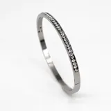 Pulsera rígida plateada de acero con cristales incrustados de circonia cúbica.