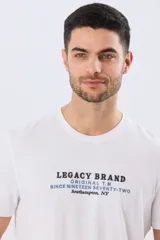 Remera blanca de manga corta y cuello redondo, confeccionada en algodón con bordado frontal de texto en tonos negro y azul.