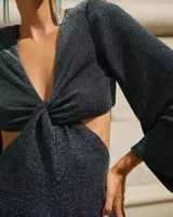 Vestido largo color verde esmeralda, con escote en V, corte a la cintura y falda con abertura lateral. Mangas largas acampanadas y espalda descubierta.