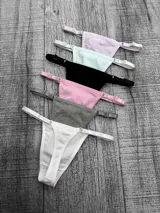 Pack de seis bombachas tipo colaless de algodón, con tiras laterales regulables y herrajes metálicos. El set incluye colores variados como blanco, gris, rosa, negro, verde agua y lila.