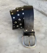 Cinturón de cuero vacuno color marrón con tachas metálicas plateadas.