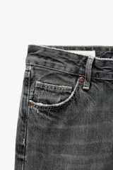Jeans de tiro bajo con diseño wide leg y corte full length. Presenta cinco bolsillos, cierre frontal con cremallera y botón metálico, en un lavado de denim claro.