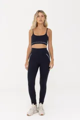 Top deportivo negro con breteles finos regulables y contorno inferior blanco.