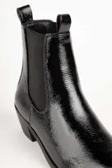 Bota de cuero color marrón con elástico negro en los laterales, caña baja, punta fina y taco cuadrado.