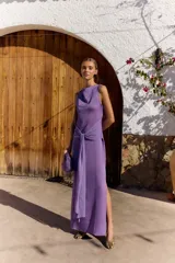 Vestido largo violeta Lady Pipa con escote drapeado, sin mangas, detalle de lazo cruzado en la cintura y tajo lateral en la falda.
