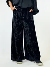 Pantalón palazzo de terciopelo color borgoña con textura arrugada y bolsillos laterales.