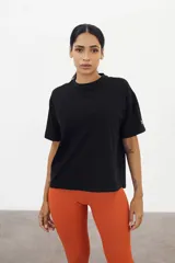 Remera negra de algodón con mangas cortas amplias y cuello redondo.