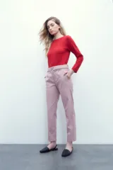 Pantalón rosa pastel con cintura elastizada, bolsillos laterales y cinto con hebilla metálica.