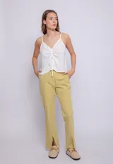 Top blanco de tirantes finos, escote en V con fruncido central ajustable mediante lazos.