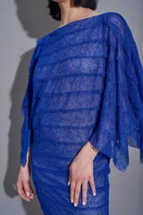 Vestido corto de encaje azul con volados y mangas anchas transparentes.