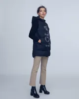 Chaleco largo negro estilo puffer con capucha y cierre frontal.